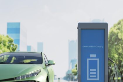 A sleek electric car parked under a blue sky, with charging cables plugged in at a modern EV charging station, symbolizing the future of sustainable transportation.