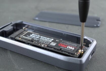 An external SSD connected to a laptop with a USB cable.