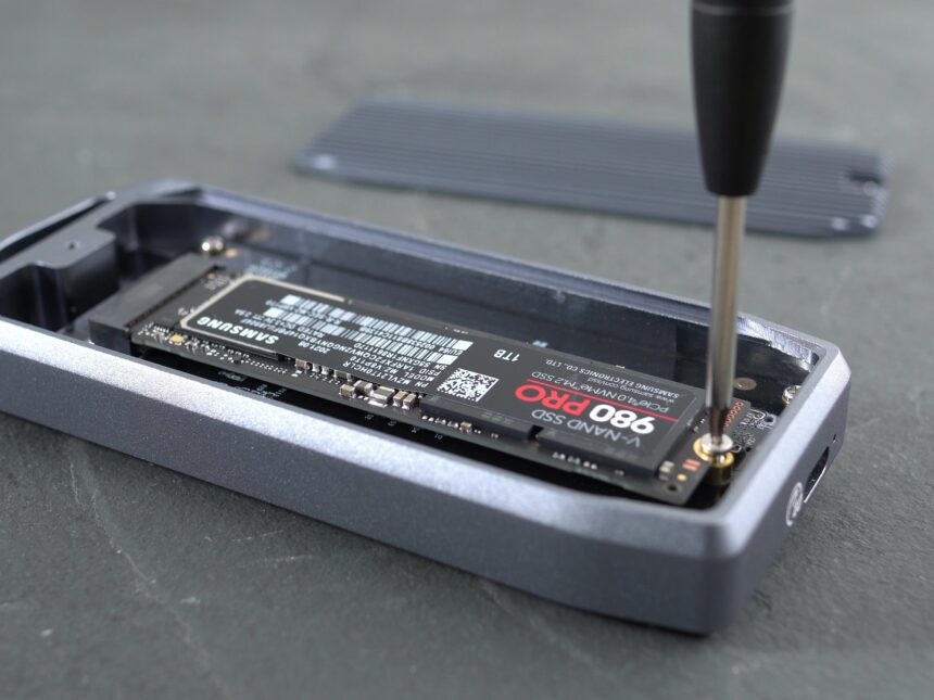 An external SSD connected to a laptop with a USB cable.