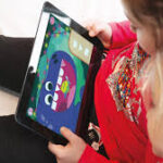 child-using-educational-tablet-app